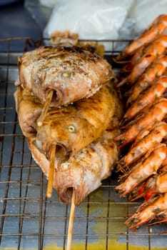 seafood fish and shrimp cooked on the grill in a street in Thailand closeup