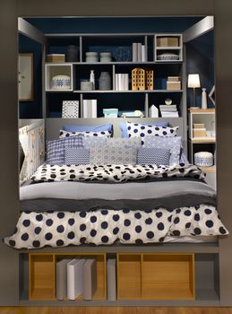 design of sleeping room with modern bed, bed clothes book shelf and small gadgets.