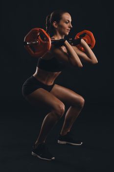 Shot of a beautiful young woman in a workout gear lifting weights