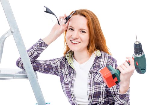 Happy housewife with tools wearing a plaid shirt, a portrait on a white background