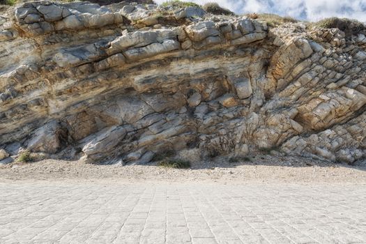 Floor of paving stones with stone wall in the background