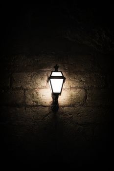 A luminous lantern on a stone wall