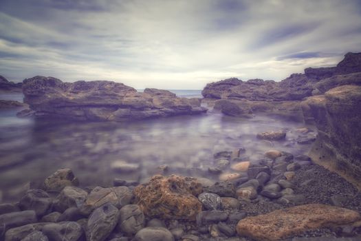 Long exposure at the sea with rocks and fog
