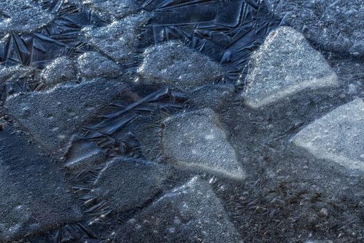 Many small cracked ice sheets on a lake