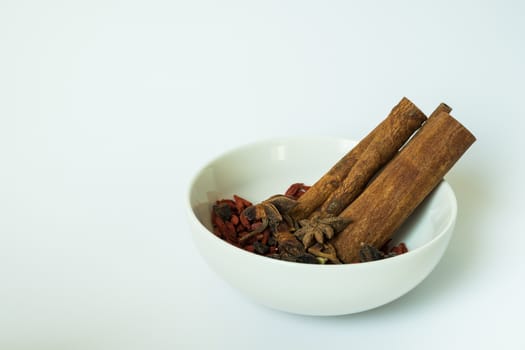 Traditional chinese dried herbs in a white bowl, used for cooking