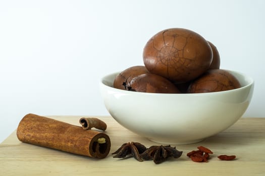 Tradional chinese herbs on chopping board and herbal eggs in a white bowl