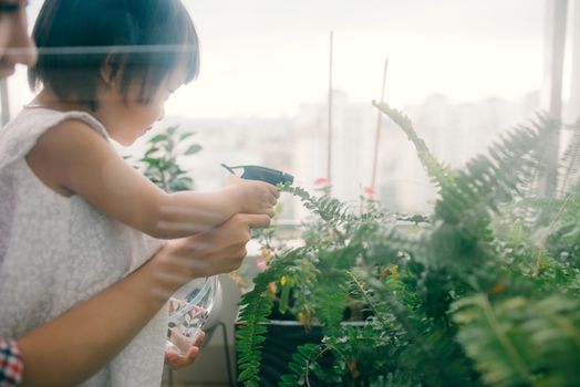 Happy mother and child daughter water in small garden