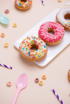 Preparation for the holiday. Colorful american donuts on pink background