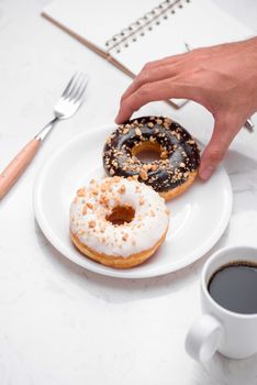 Fast food breakfast with donut and coffee on marble table top. 