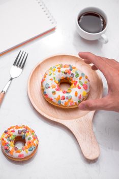 Fast food breakfast with donut and coffee on marble table top.