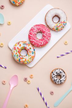 Preparation for the holiday. Colorful american donuts on pink background