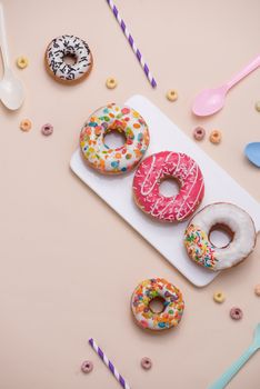 Preparation for the holiday. Colorful american donuts on pink background