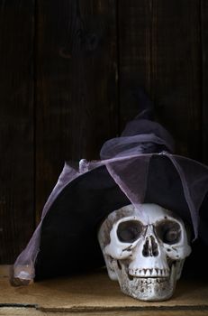 Human skull with magician hat at the wooden wall