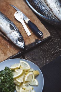 Fish with herbs and vegetables on a wooden table