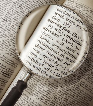 Magnifying Glass Focused On The Word Success In A Vintage Dictionary