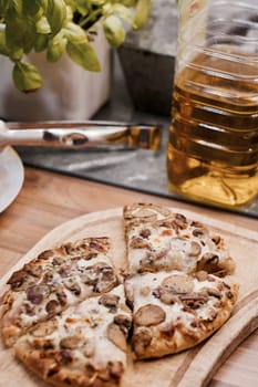 Tasty and fresh italian pizza in the kitchen on the wooden board.