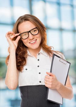 successful woman corrects glasses in the office