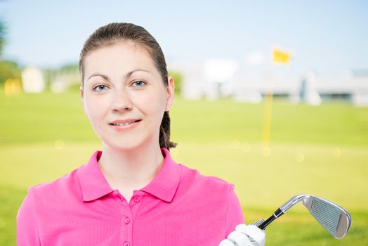 horizontal portrait of the girl with a golf club in a pink polo shirt