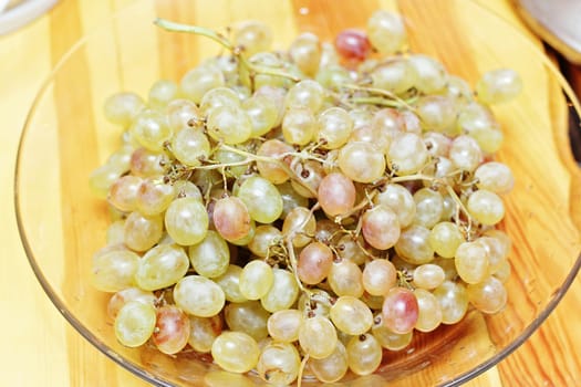 Juicy bunches of ripe grapes on a glass plate.