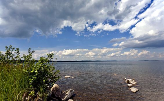 quiet lake Uvildy early in the morning, clear water, clear bottom, South Ural, in the distance are seen the Ural mountains