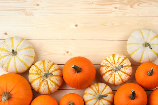 Many orange pumpkins on wooden background, autumn harvest, Halloween or Thanksgiving concept