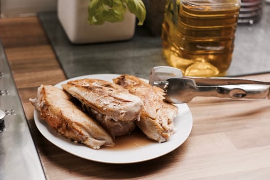 Fresh and delicious grilled chicken on white plate in the kitchen. Food concept.