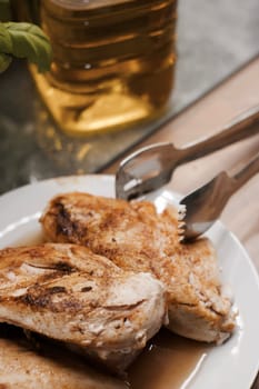 Fresh and delicious grilled chicken on white plate in the kitchen. Food concept.