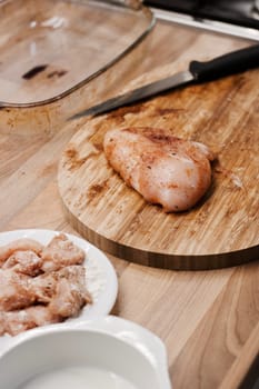 Fresh chicken meat on the wooden board in the kitchen. Home cooking concept.