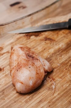 Fresh chicken meat on the wooden board in the kitchen. Home cooking concept.