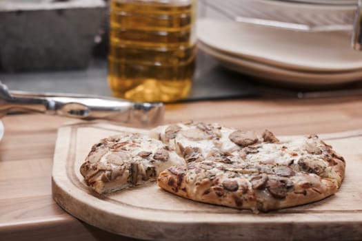 Tasty and fresh italian pizza in the kitchen on the wooden board.