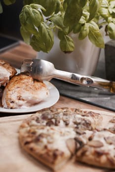 Tasty and fresh italian pizza in the kitchen on the wooden board.