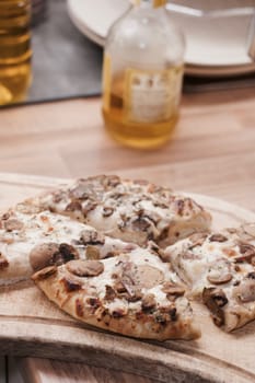 Tasty and fresh italian pizza in the kitchen on the wooden board.