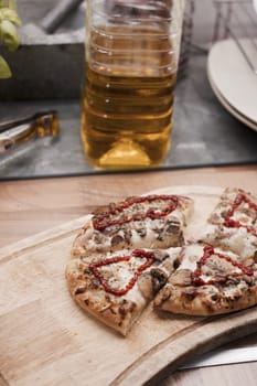 Tasty and fresh italian pizza in the kitchen on the wooden board.