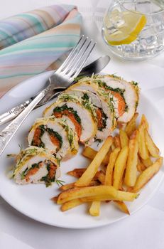 Roll from chicken breast with spinach and carrots under a crust of parmesan, dill, garnish of french fries