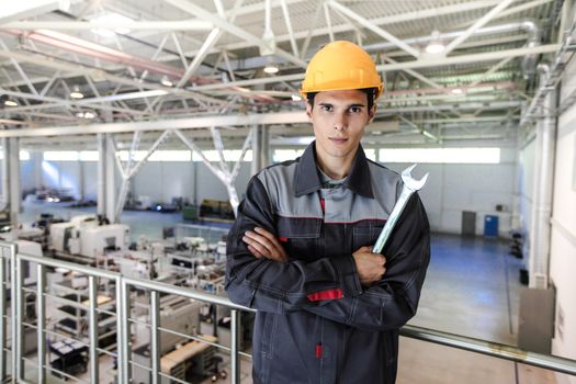 Portrait of young worker with wrench at CNC factory