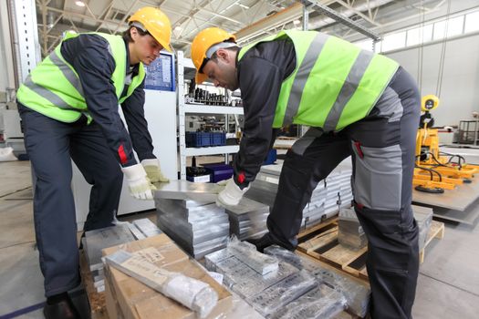 Workers taking aluminium billet at CNC machine shop