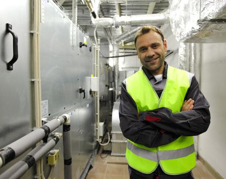 Portrait of smiling worker in electrical switchgear room of CNC plant