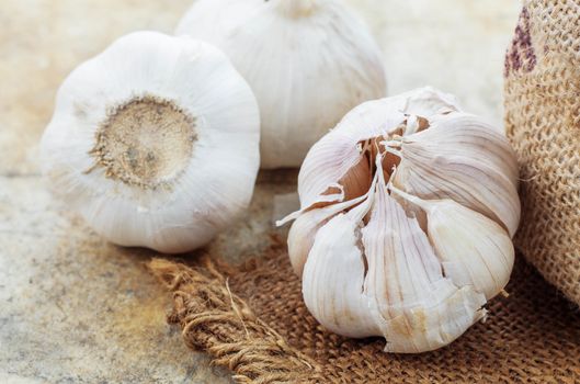 Garlic on sackcloth with concrete floor.