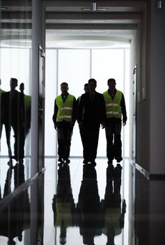 Team of workers and manager walking at the corridor of factory