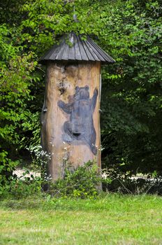 Traditional colorful and picturesque wooden bee hive made of tree trunk and a bear painted in Slovenia. The hives are painted to allow the bees find their hives.