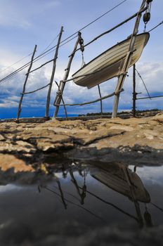 Traditional hoisting of boats ashore in northern Adriatic sea, a small fisher boat hoisted out of the water