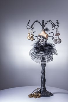 Black jewelery display stand / hanger in form of a woman’s bust in black and white dress with metallic arms as holders