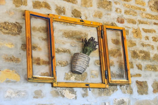 Lavender bunch in pot, in wooden frame and serving as wall decoration