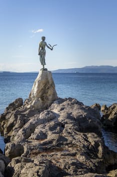 Maiden girl holding a seagull and facing the sea, statue on rocks, Opatija, Croatia