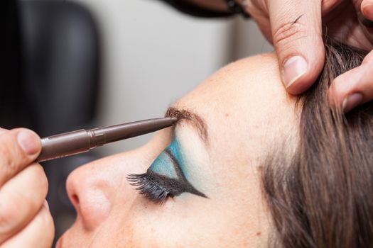 Makeup artist applying makeup on eyebrows