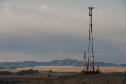 Telecommunications cell phone tower with antennas in a mountain location.