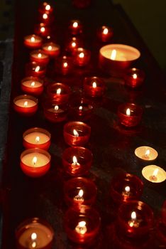 rows of red candles in church