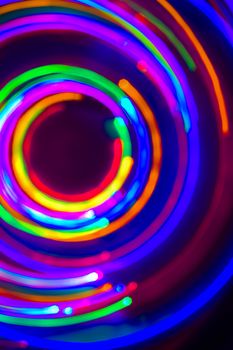 Christmas tree lights spun around to achieve a spiral glowing effect; abstract circular color trails, defocused, abstract