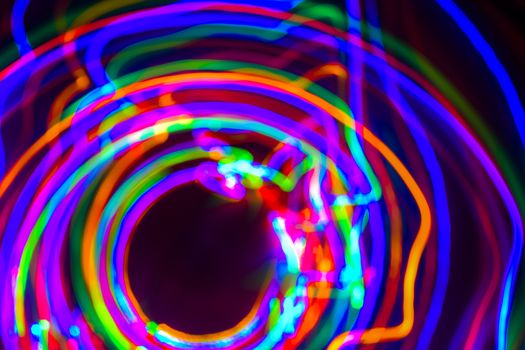 Christmas tree lights spun around to achieve a spiral glowing effect; abstract circular color trails, defocused, abstract