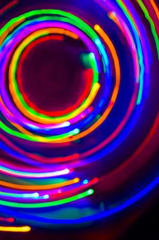 Christmas tree lights spun around to achieve a spiral glowing effect; abstract circular color trails, defocused, abstract